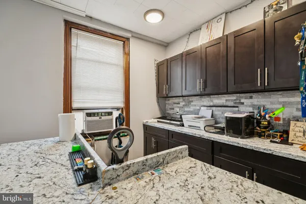 a kitchen with granite countertop a stove top oven microwave and cabinets