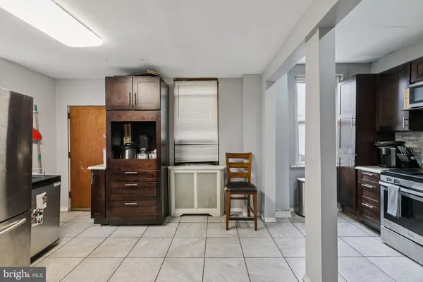 a kitchen with stainless steel appliances granite countertop a stove top oven a sink and a refrigerator