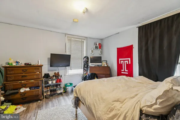 a bedroom with bed and wooden floor