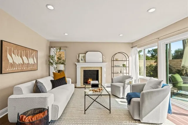 a living room with furniture a fireplace and a large window