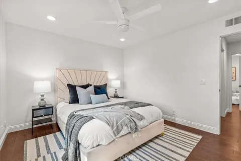 a bedroom with a bed and wooden floor