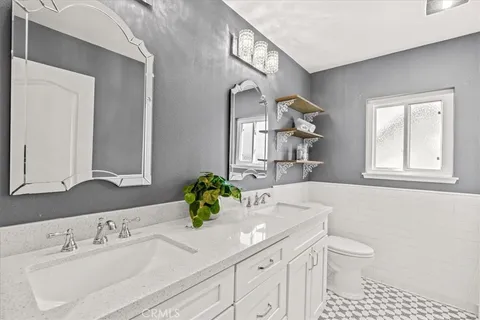 a bathroom with a sink a toilet and a mirror