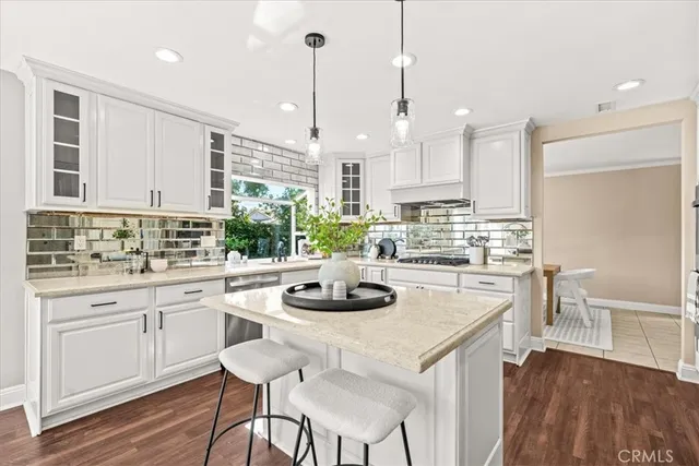 a kitchen with a stove a sink and white cabinets