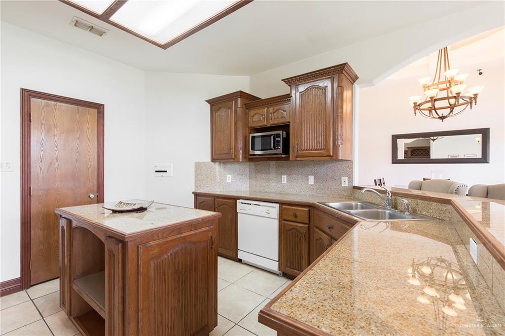 1213 Rhett Drive Pharr, TX 78577 - Photo 7 of 19 Open-concept kitchen with granite countertops, custom wood cabinetry, and ample prep space.