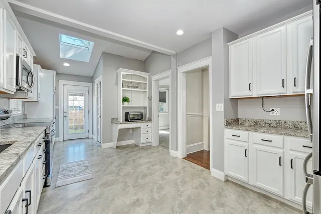 a large kitchen with cabinets and wooden floor