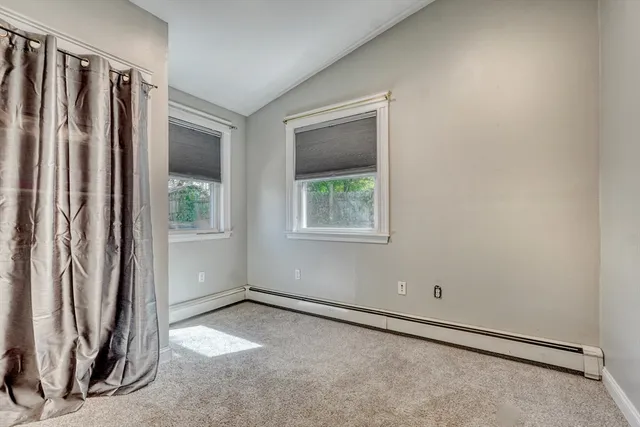 an empty room with a window and a bathroom