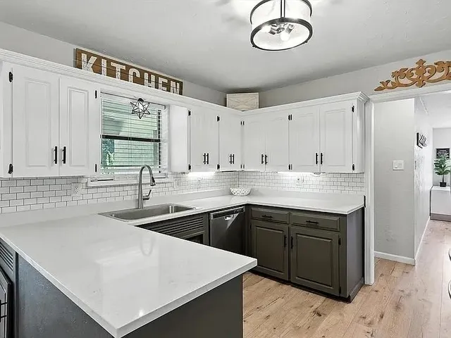 a kitchen with stainless steel appliances granite countertop a sink a stove and a refrigerator