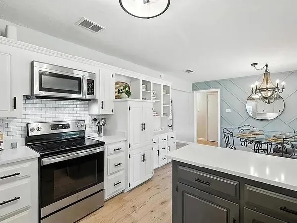 a kitchen with stainless steel appliances a stove microwave and a refrigerator