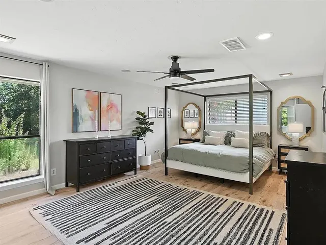a bedroom with a bed window and dresser