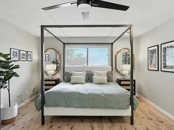 a bedroom with a large bed and a potted plant