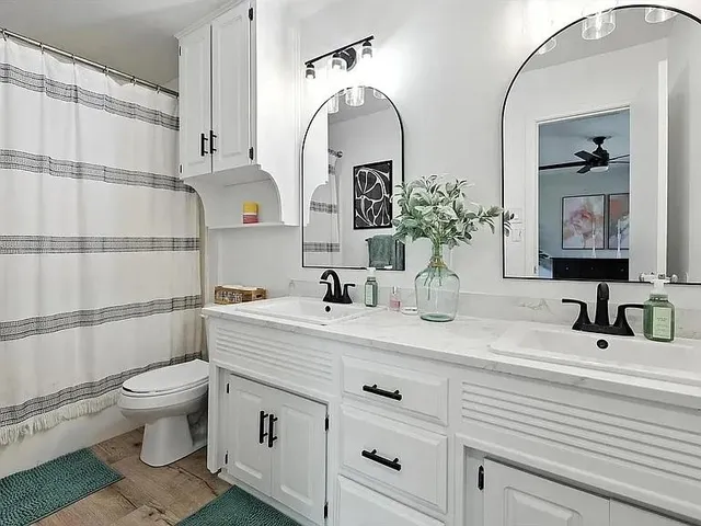 a bathroom with a double vanity sink mirror and toilet