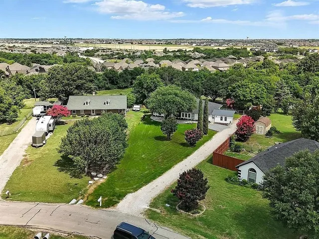 an aerial view of residential houses with outdoor space and trees