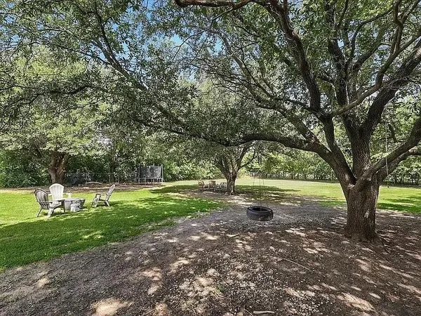 a view of a field with grass and trees
