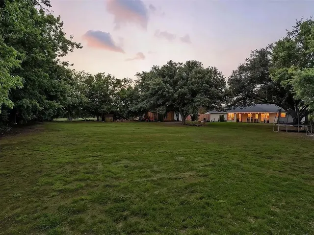 a backyard of a house with table and chairs