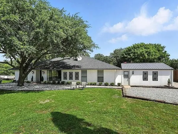 a front view of house with a garden and trees