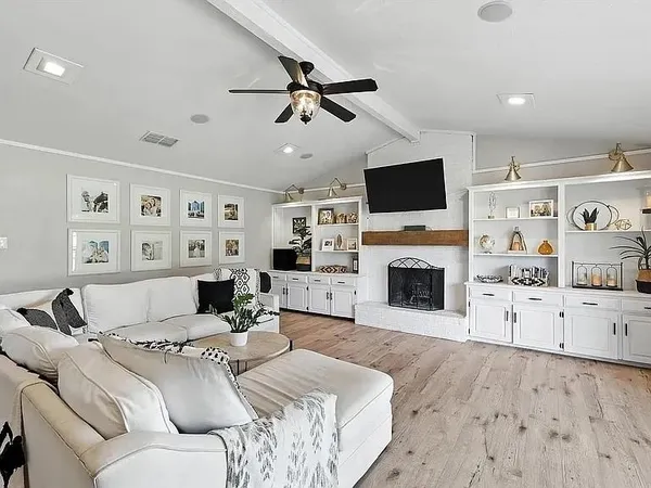 a living room with furniture a fireplace and a flat screen tv