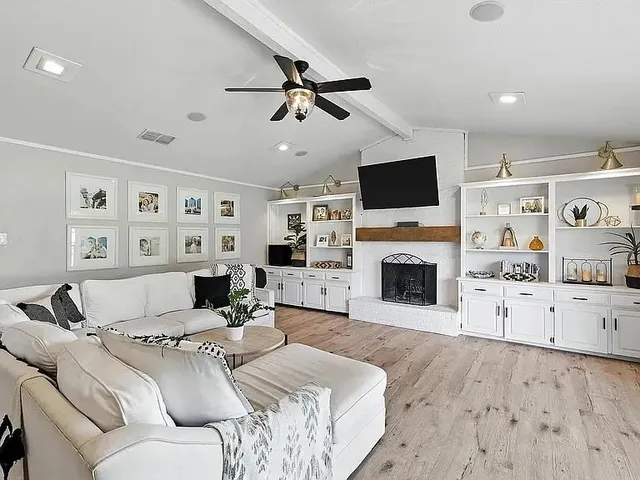 a living room with furniture a fireplace and a flat screen tv