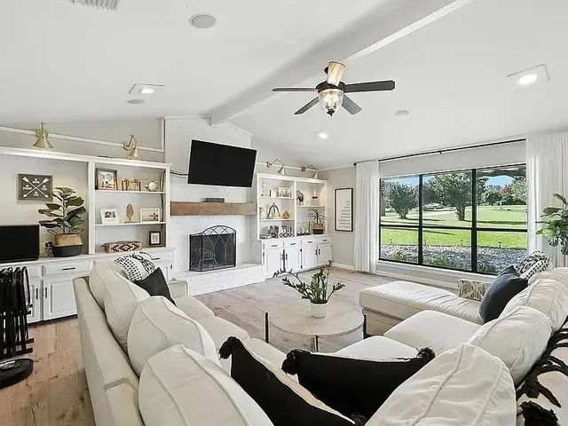 a living room with furniture a fireplace and a flat screen tv