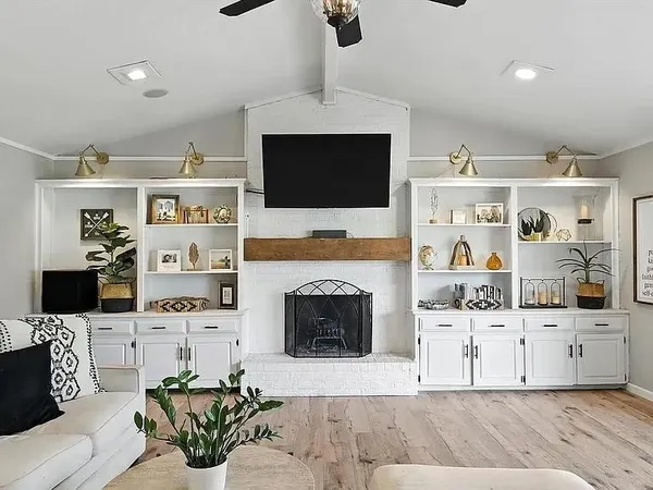 a living room with furniture a fireplace and a flat screen tv