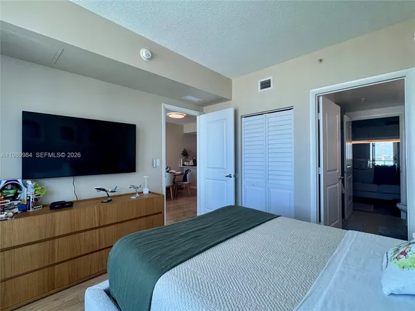 a bedroom with a bed and a flat screen tv