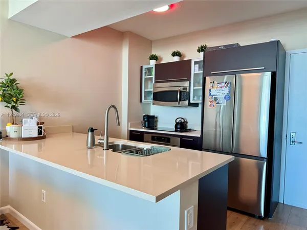 a kitchen with stainless steel appliances a sink and a refrigerator