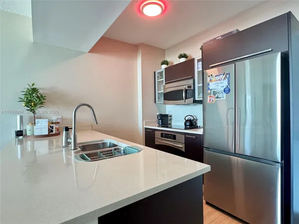 a kitchen with stainless steel appliances a refrigerator a sink a stove and cabinets