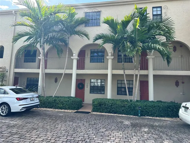 a front view of a house with garden and plants