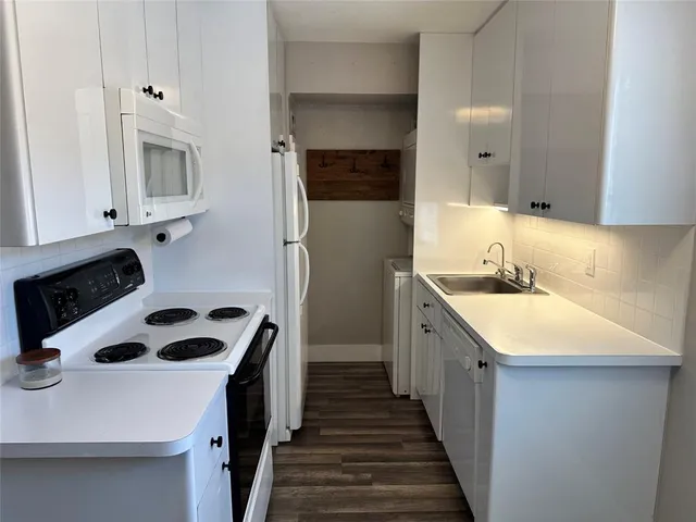 a kitchen with a sink dishwasher a stove and a refrigerator with wooden floor