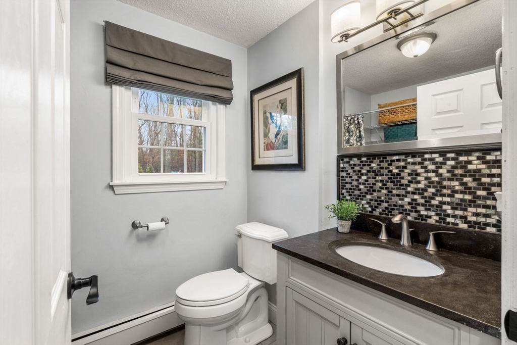 6 Ridge Hill Way Andover, MA 01810 - Photo 14 of 42 a bathroom with a granite countertop toilet a sink a mirror a window and a shower