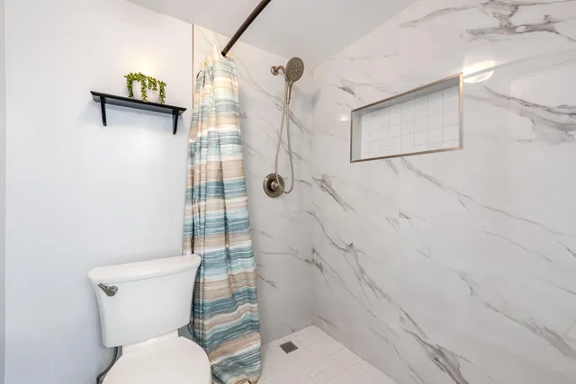 a bathroom with a toilet and a shower