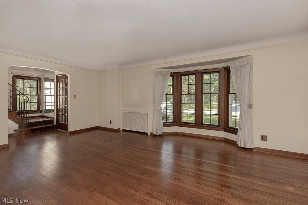 Another view of the living room, front door and stairs to the 2nd level on the left.