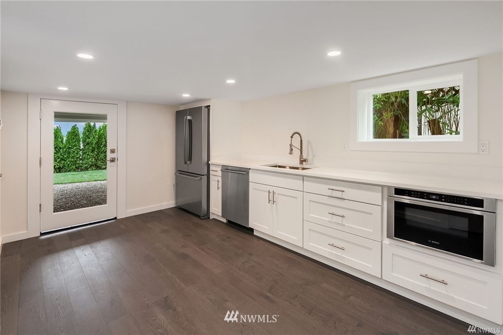 206 30th Avenue Seattle, WA 98122 - Photo 19 of 21 a kitchen with stainless steel appliances kitchen island wooden cabinets and granite counter tops
