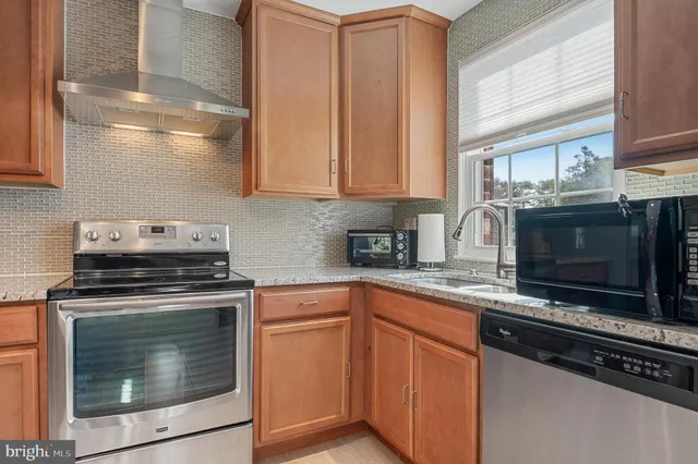 a kitchen with stainless steel appliances granite countertop a stove microwave and sink