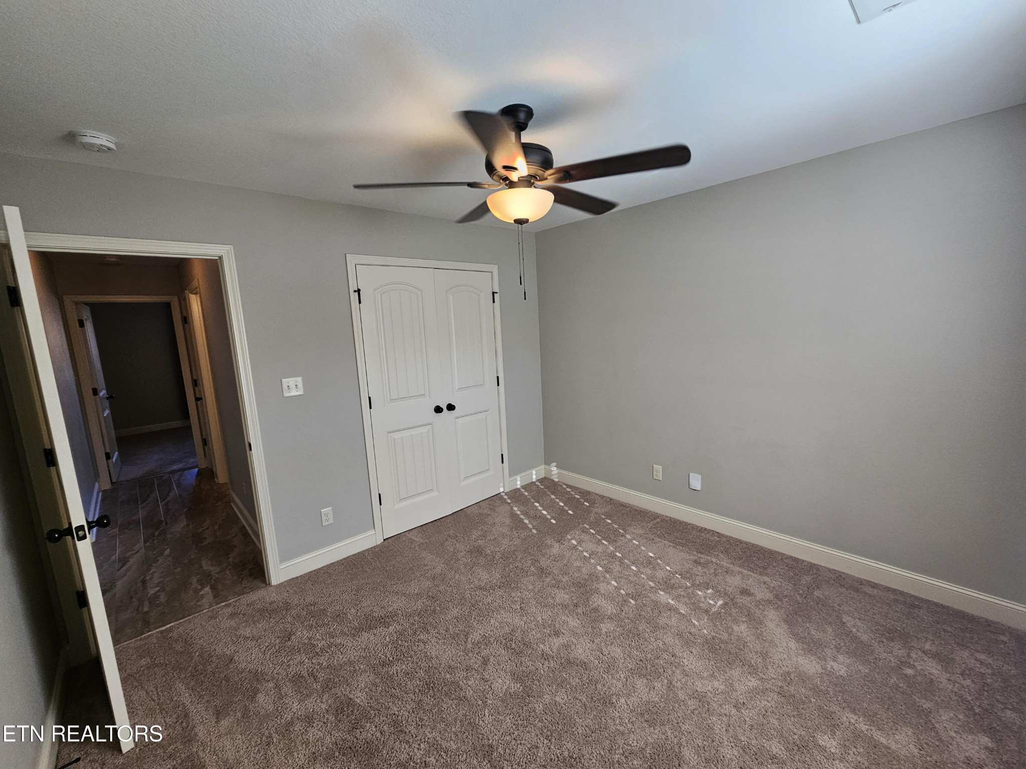 5920 Whisper Ridge Lane Corryton, TN 37721 - Photo 31 of 49 an empty room with closet and a chandelier fan