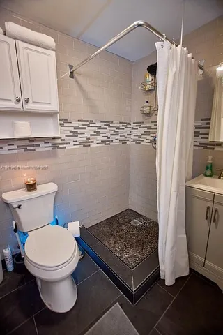a bathroom with a toilet and a shower