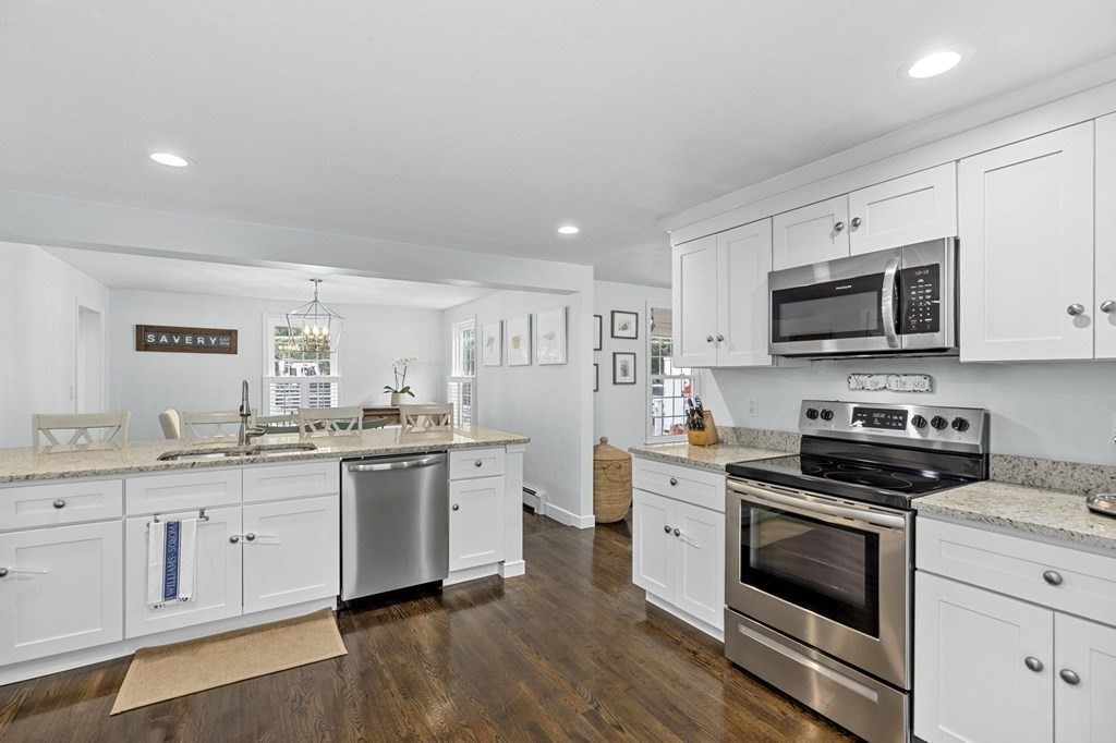37 Old Forge Road Scituate, MA 02066 - Photo 15 of 42 a kitchen with stainless steel appliances granite countertop white cabinets a sink a stove a microwave and wooden floors