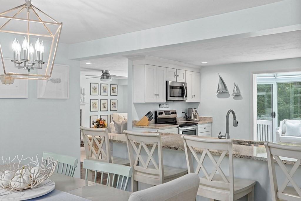 37 Old Forge Road Scituate, MA 02066 - Photo 8 of 42 a kitchen with stainless steel appliances kitchen island granite countertop a stove a sink a dining table and chairs