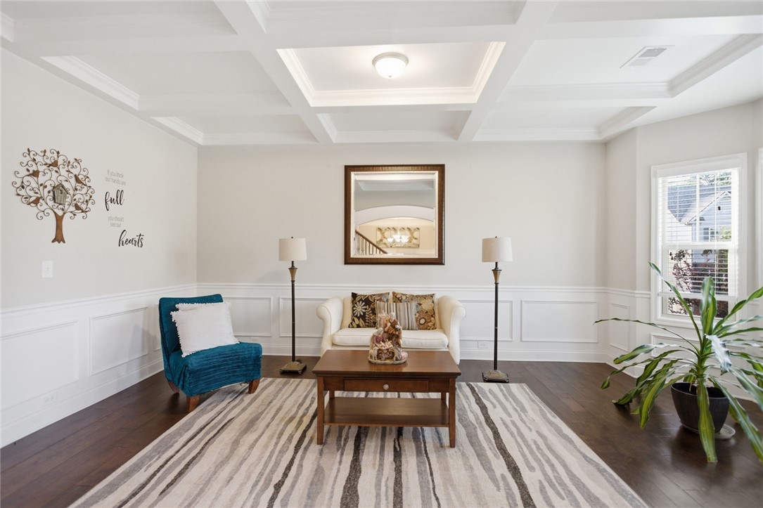 120 Jones Creek Circle Anderson, SC 29621 - Photo 13 of 43 This bright living space features elegant wainscoting and a distinctive coffered ceiling, enhancing its architectural appeal.