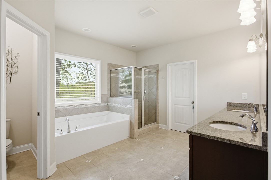 120 Jones Creek Circle Anderson, SC 29621 - Photo 22 of 43 This serene bathroom offers a spacious soaking tub, separate shower, and a double vanity with granite counters.