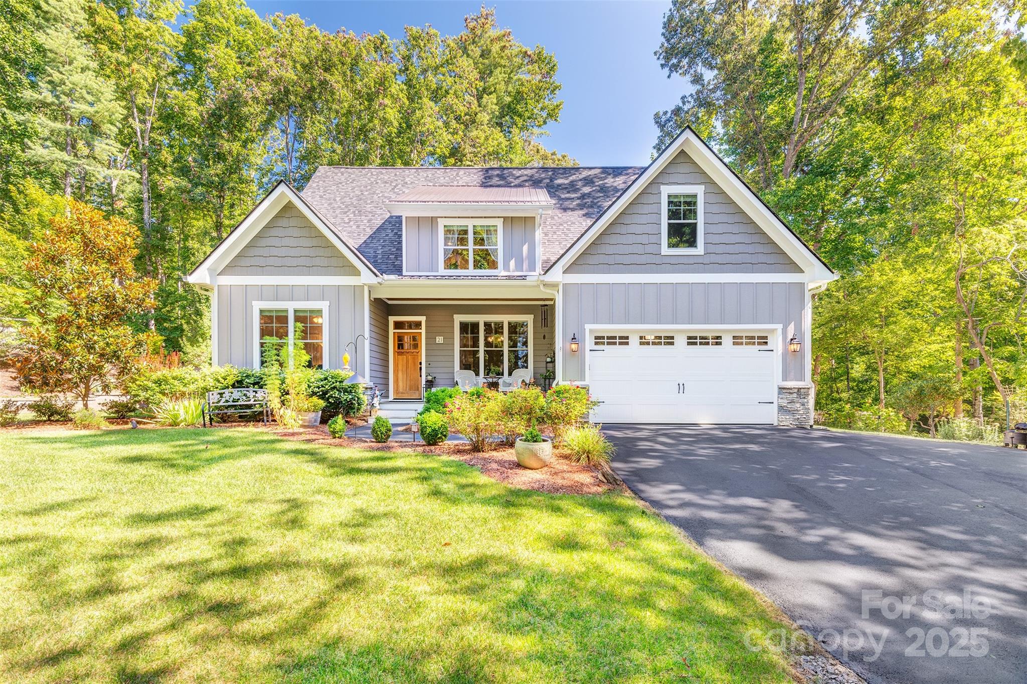 a front view of a house with a yard and trees
