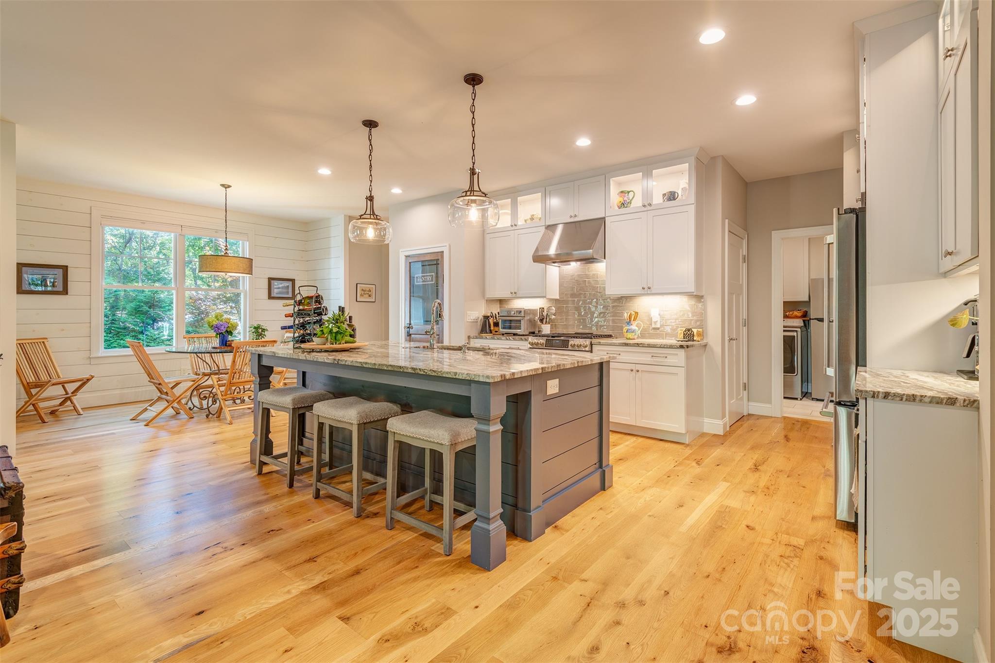 21 Ducketts Grove Road Fletcher, NC 28732 - Photo 11 of 42 a kitchen with stainless steel appliances kitchen island granite countertop a stove a refrigerator a oven and a dining table with wooden floor