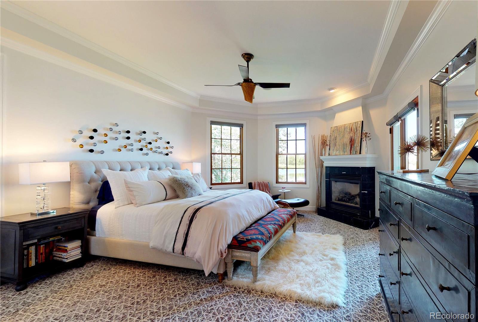 1820 Seashell Court Windsor, CO 80550 - Photo 18 of 40 a bedroom with a large bed and a fireplace