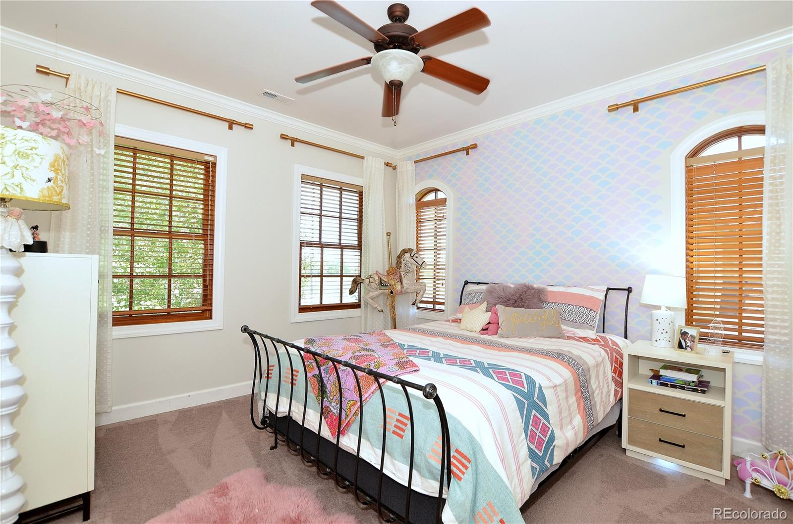 1820 Seashell Court Windsor, CO 80550 - Photo 25 of 40 a bedroom with a bed and a chandelier