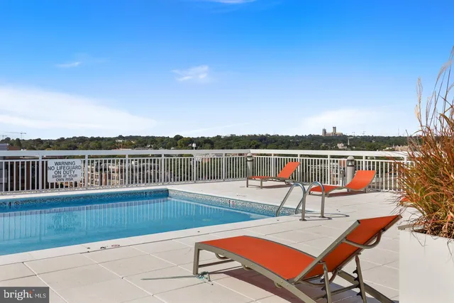 a view of swimming pool with lake view and trees in the background