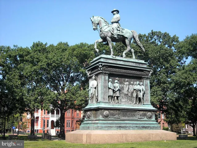 a front view of a building with trees and flowers