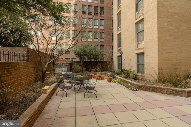 a view of a patio with couches and table and chairs with wooden floor and fence