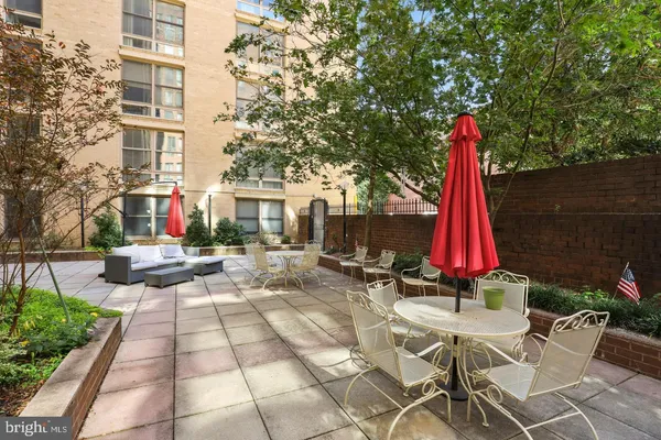 a view of a white house with a yard and sitting area