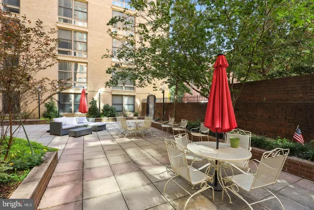 a view of a white house with a yard and sitting area