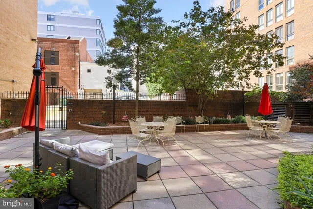 a view of a patio with table and chairs potted plants and a large tree