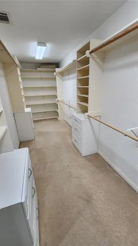 a view of an empty room with stairs and a hallway
